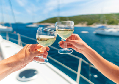 A man and a woman toasting champagne at a dockside yacht party